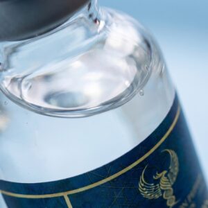 An extreme macro photograph focusing on the clear liquid and fine air bubbles inside a Resurrection Peptide Semaglutide 5mg vial, demonstrating the product's clarity and high-purity formulation.