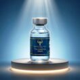 A professional studio photograph of a single 30mg Tirzepatide vial from Resurrection Peptide, featuring a dark teal and gold foil label, standing on a reflective glass surface against a soft blue gradient background.